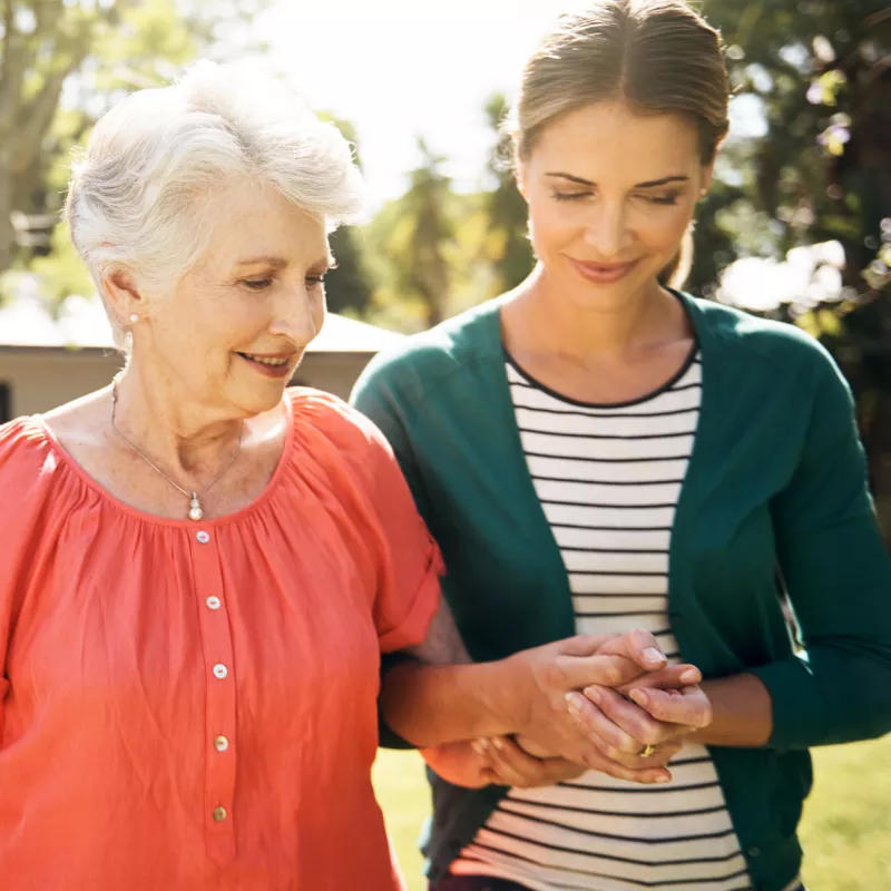 A mother and daughter, walking outside, offer emotional support to each other.