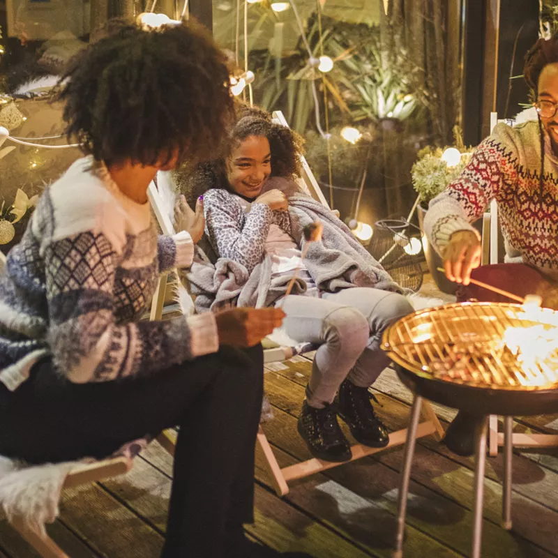 A family roasting marshmallows outside. 