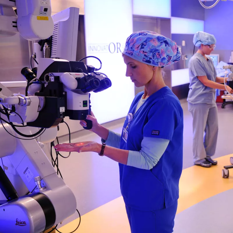 Woman inspecting robotic surgery equipment