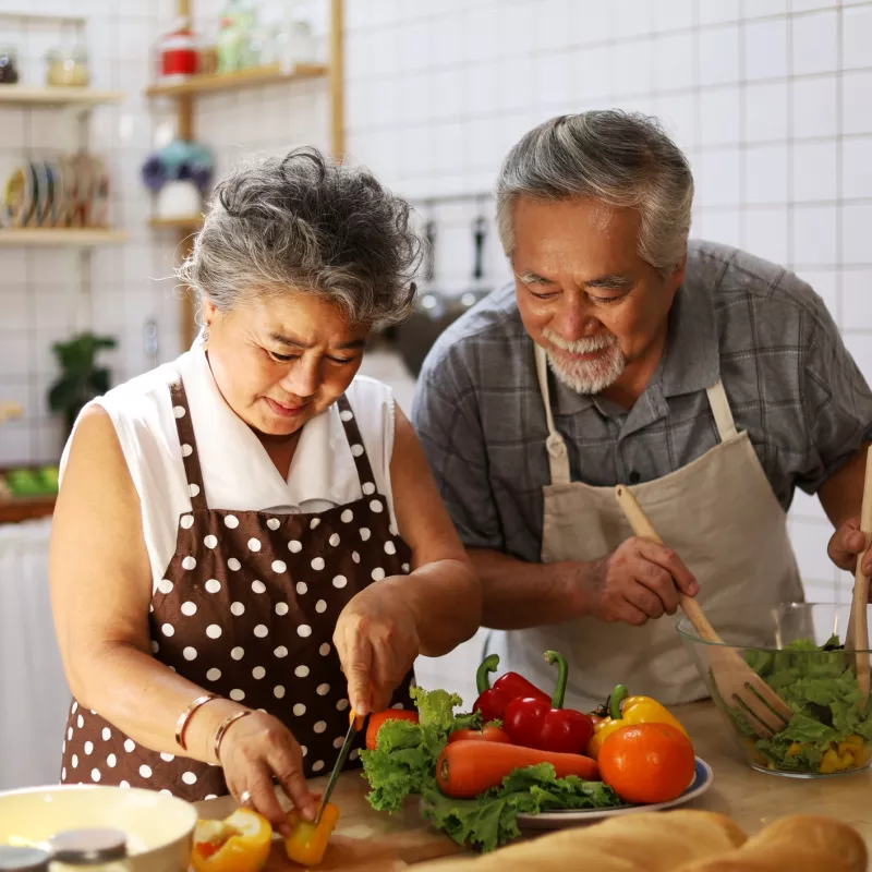 Husband and wife cooking a nice, health dinner together in the kitchen. Focusing on their digestive health.