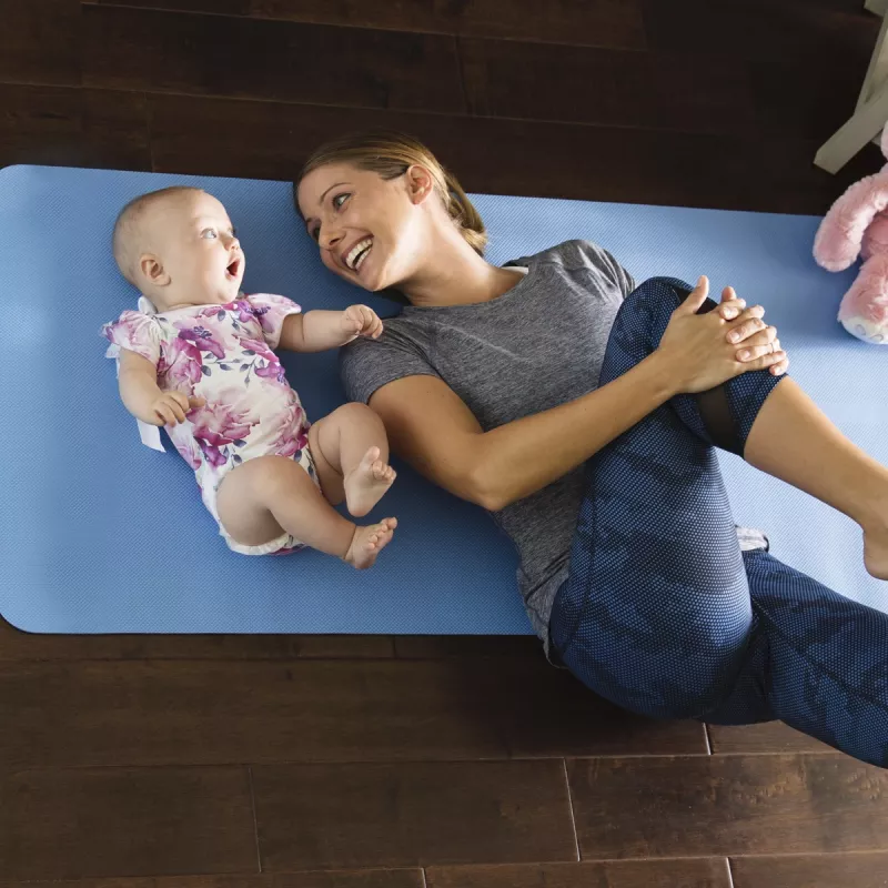 A young mother plays on the floor with her toddler.