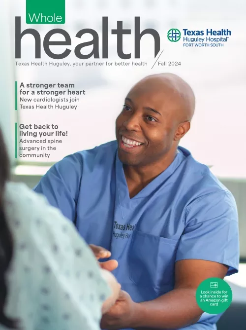 Physician in his scrubs, talking to a patient about their care.